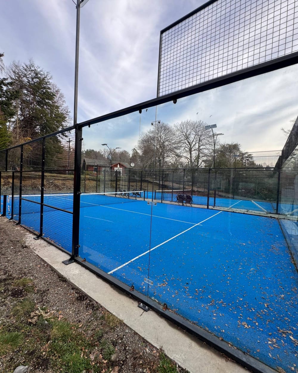 Cancha outdoor de Padel del Lago al aire libre, entre árboles, con vidrio templado